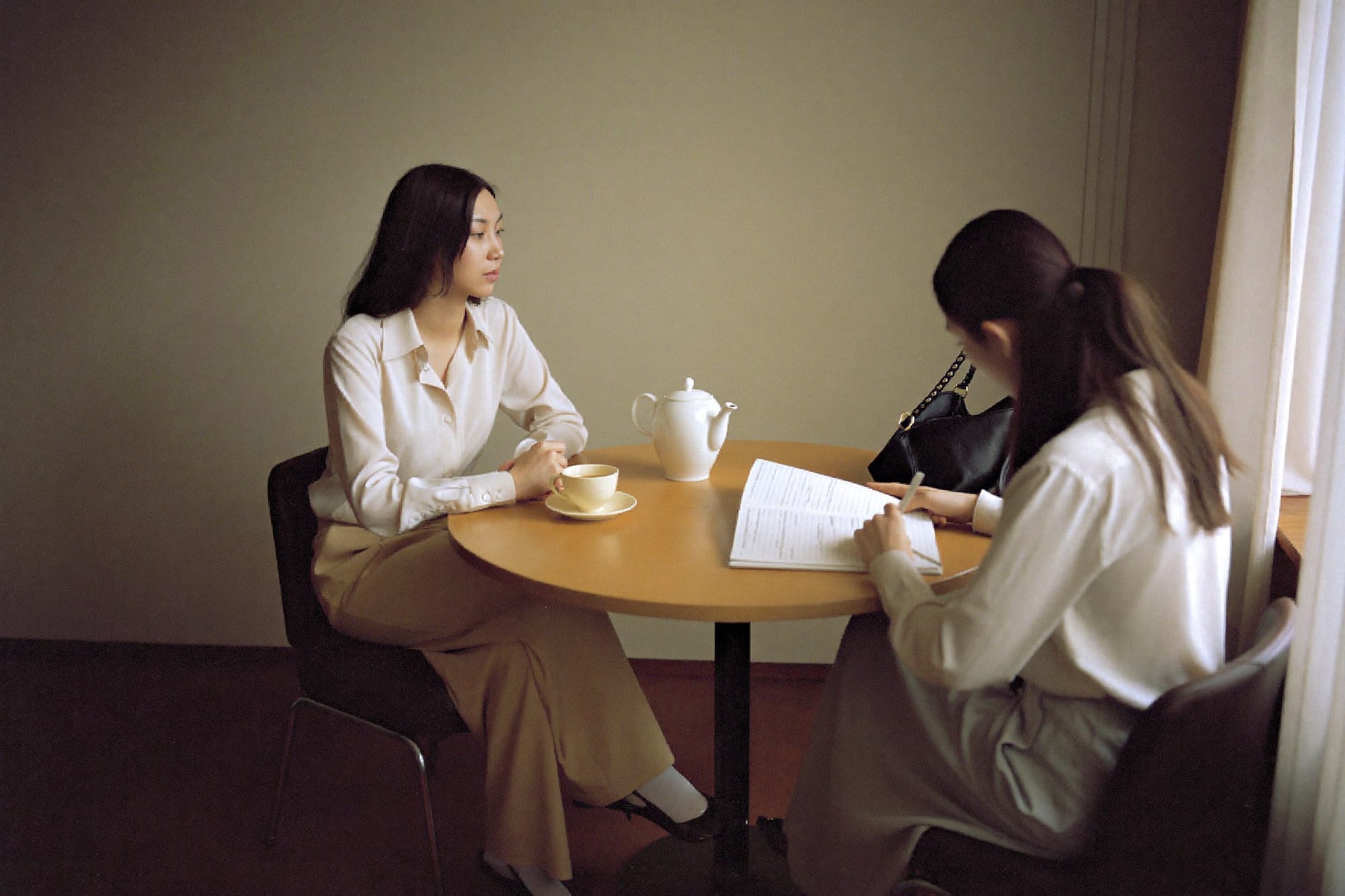Two women in conversation over tea in a quiet office