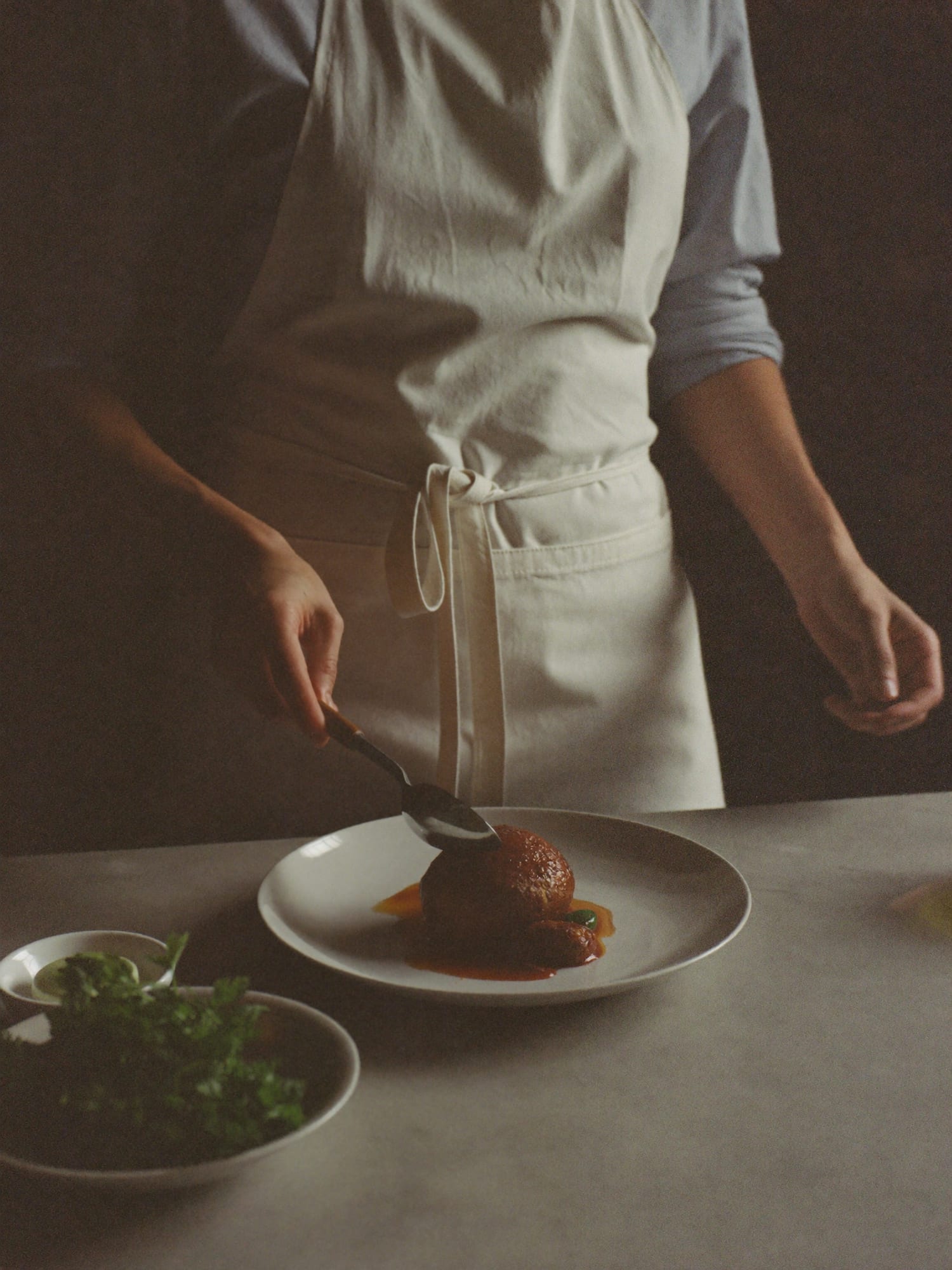 A private chef plating food at a marble kitchen island